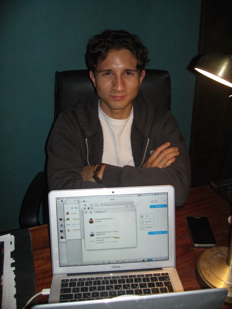 Valentino Vargas en su escritorio, con los brazos cruzados frente a un portátil con una conversación de WhatsApp
